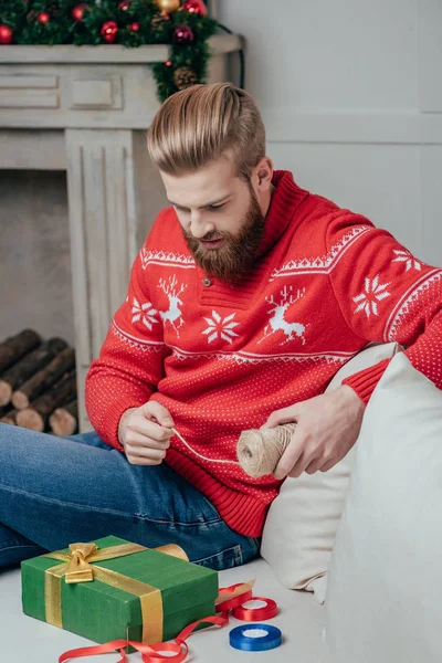 Man decorating christmas gift — Stock Photo, Image