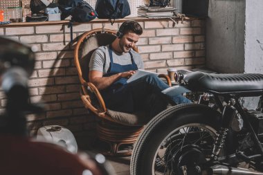 mechanic with tablet in repair shop clipart