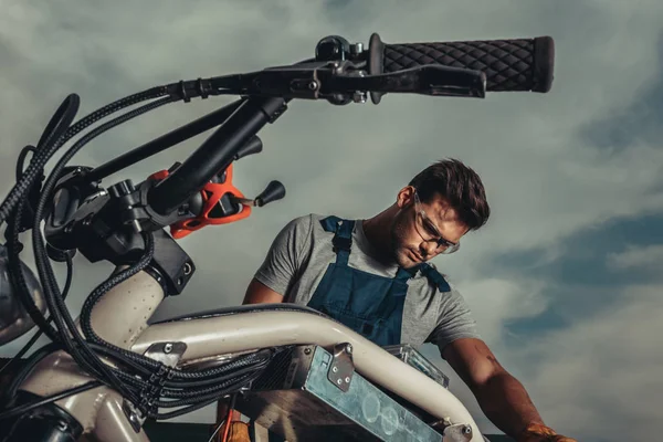Ремонтник в очках с мотоциклом — стоковое фото