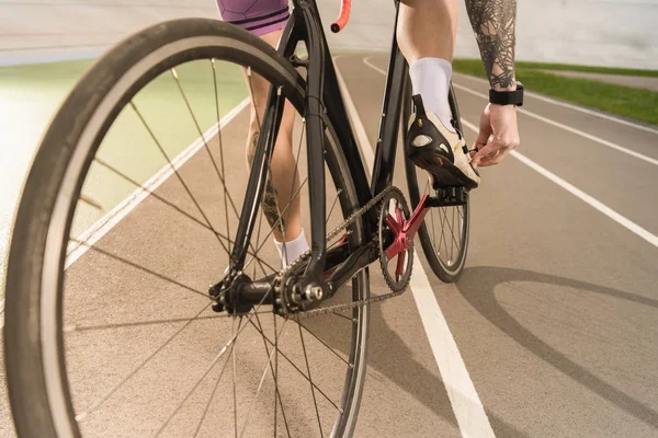 Cyclist tying shoe — Stock Photo, Image