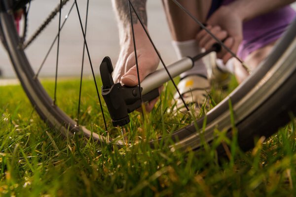 man pumping bicycle wheel