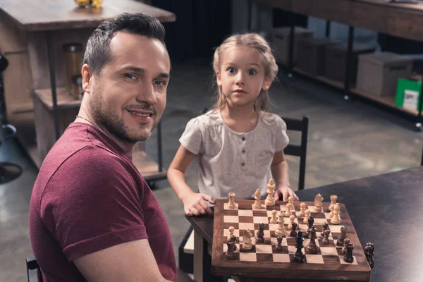 Padre e hija posando con tablero de ajedrez — Foto de Stock