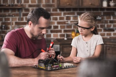 Father and daughter brazing at home clipart