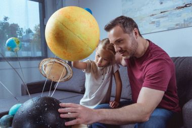 Father showing daughter planets  clipart