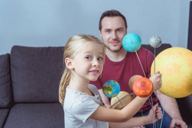 Father and daughter posing with planets  clipart