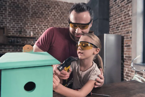 Father helping daughter use drill — Stock Photo, Image