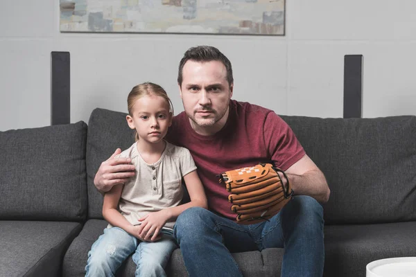 Father and daughter watching baseball game