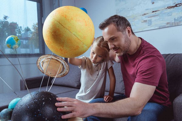 Father showing daughter planets 