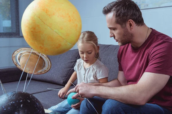 Father and daughter playing with planets — Stock Photo, Image