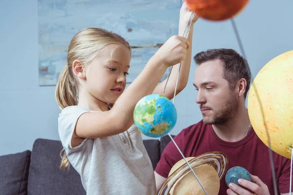 Father and daughter playing with planets — Stock Photo, Image