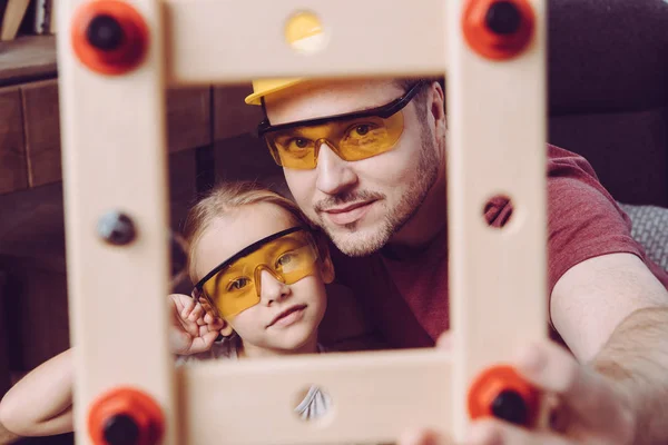 Pai e filha posando com moldura de madeira — Fotografia de Stock