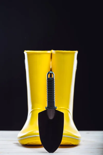 Rubber boots and garden tool — Stock Photo