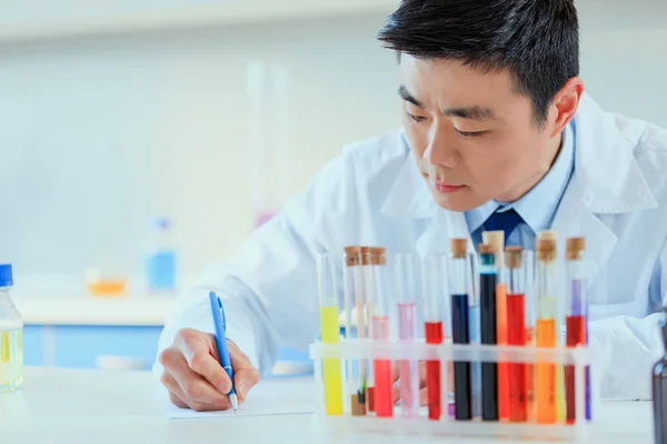 Médico asiático trabajando en laboratorio de pruebas - foto de stock