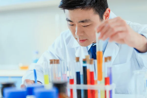 Médico asiático trabajando en laboratorio de pruebas - foto de stock