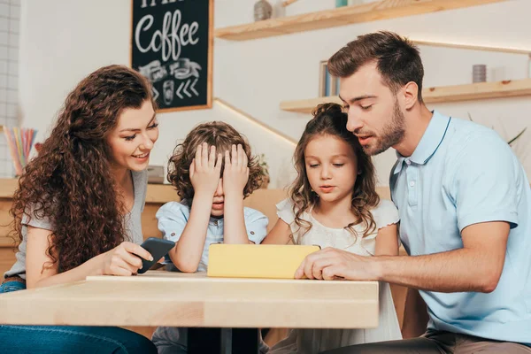 Familia joven usando tableta en la cafetería - foto de stock