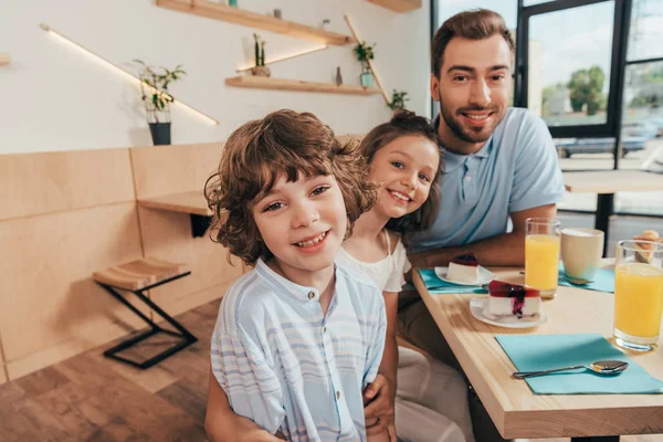 Padre y sus lindos hijos en la cafetería - foto de stock