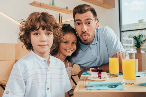 Padre y sus lindos hijos en la cafetería - foto de stock