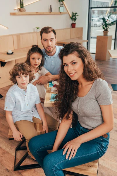 Hermosa familia joven en la cafetería - foto de stock