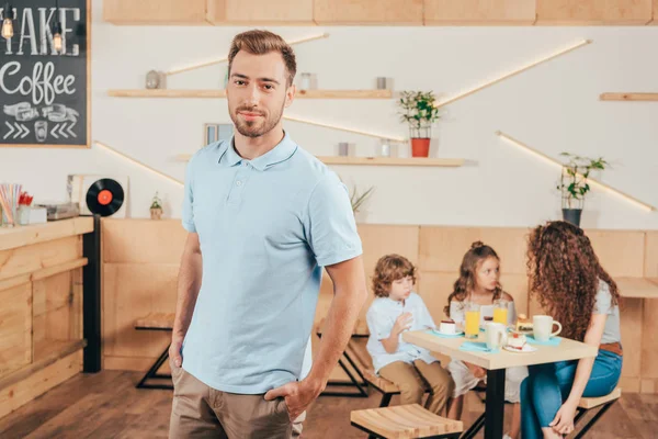 Junger schöner Mann steht im Café — Stockfoto