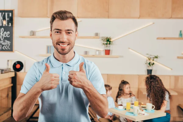 Joven mostrando pulgares hacia arriba - foto de stock
