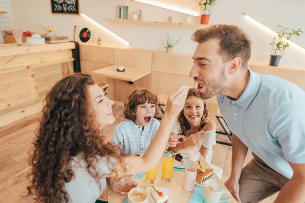 Hermosa familia joven en la cafetería - foto de stock