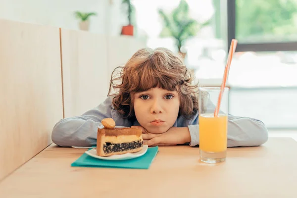 Depressed little boy in cafe — Stock Photo