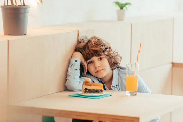 Bouclé garçon assis dans café — Photo de stock