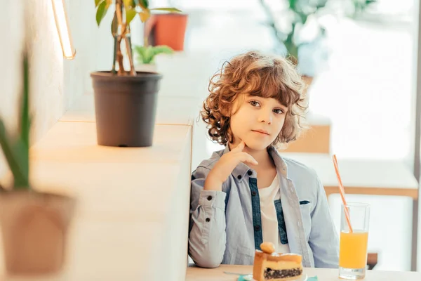 Cheerful curly boy in cafe — Stock Photo