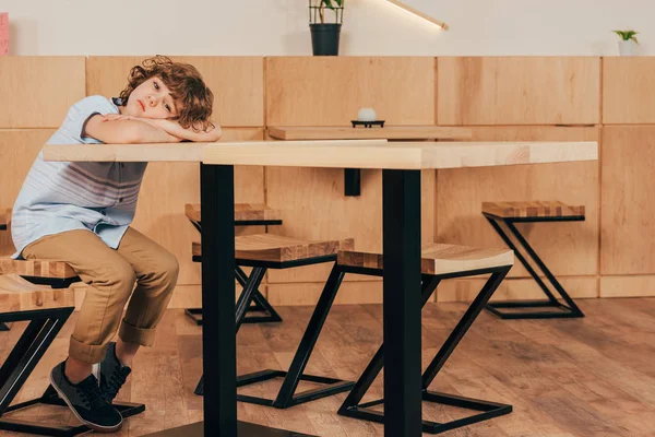 Bored little boy sitting in cafe — Stock Photo