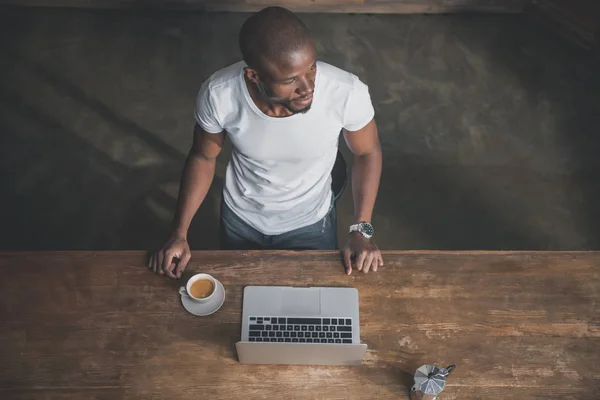 Afro-américain avec café et ordinateur portable — Photo de stock