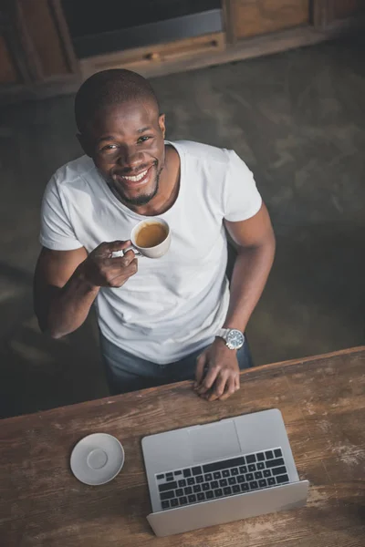 African american with coffee and laptop — Stock Photo
