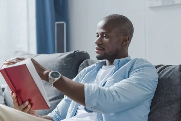 Hombre afroamericano leyendo libro - foto de stock