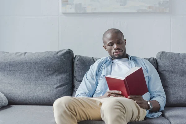 Hombre afroamericano leyendo libro - foto de stock