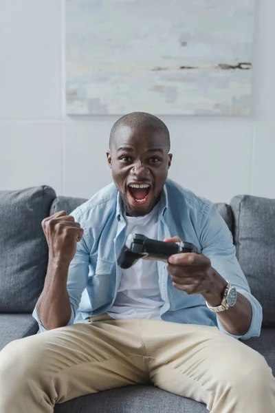 Hombre afroamericano jugando con joystick - foto de stock