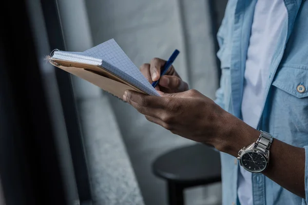 Hombre afroamericano escribiendo notas - foto de stock