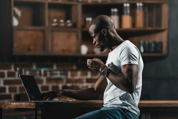 African american man with coffee and laptop — Stock Photo