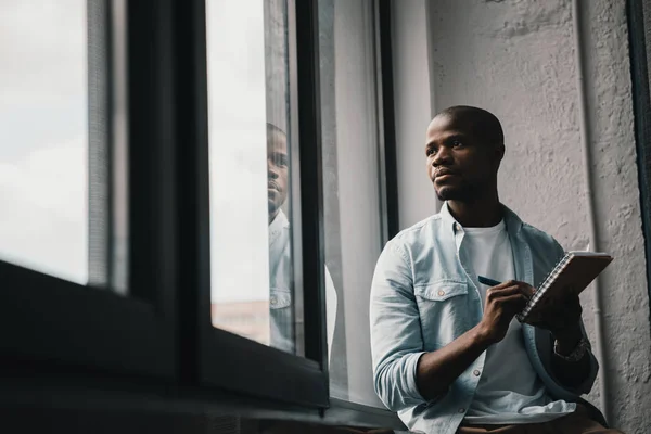 Hombre afroamericano mirando a la ventana — Stock Photo