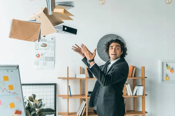 Businessman throwing folders in office — Stock Photo