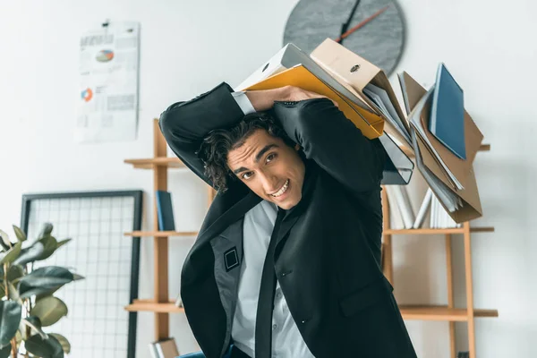 Businessman and falling folders in office — Stock Photo