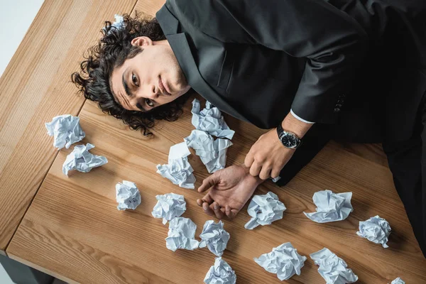 Businessman lying on table in office — Stock Photo