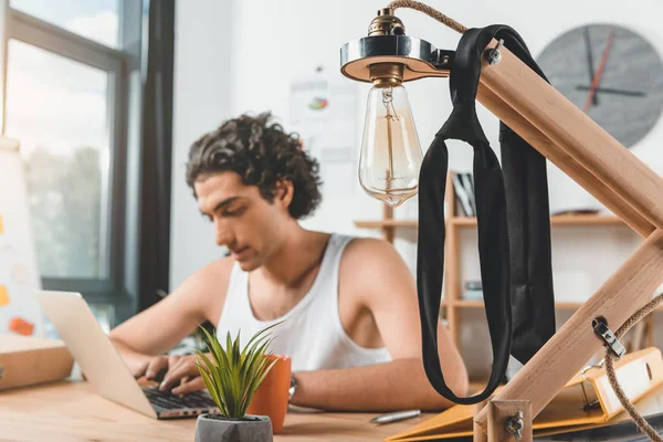 Hombre de negocios escribiendo en el ordenador portátil en el lugar de trabajo - foto de stock