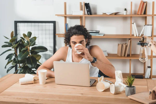 Businessman drinking coffee while working — Stock Photo