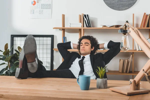 Hombre de negocios descansando en el lugar de trabajo en la oficina - foto de stock