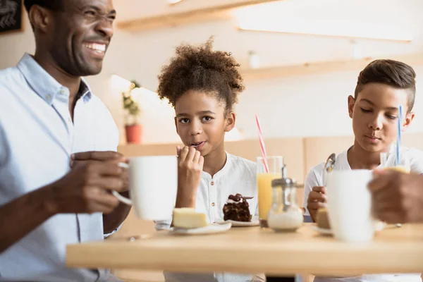 Отец и дети в кафе — стоковое фото