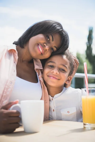 Feliz madre e hija en la cafetería - foto de stock