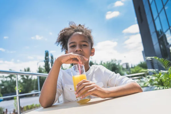 Afro girl with orange juice — Stock Photo