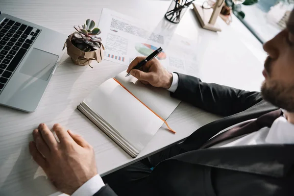 Hombre de negocios escribiendo en cuaderno - foto de stock