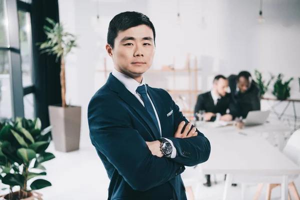 Asian businessman with folded arms — Stock Photo