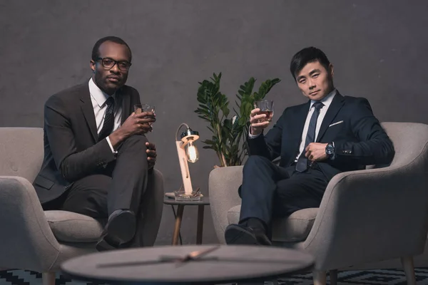 Multiethic businessmen relaxing on armchairs — Stock Photo