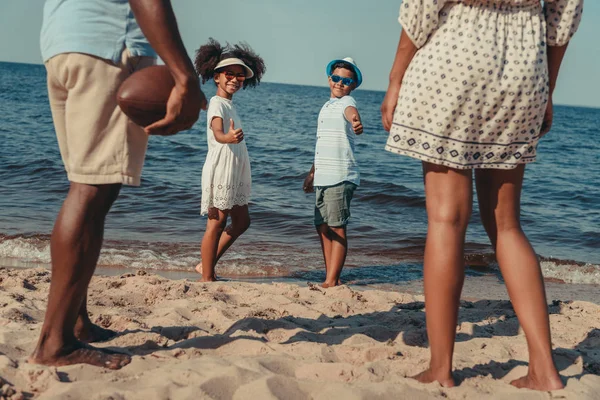 Familia jugando con pelota en la playa - foto de stock